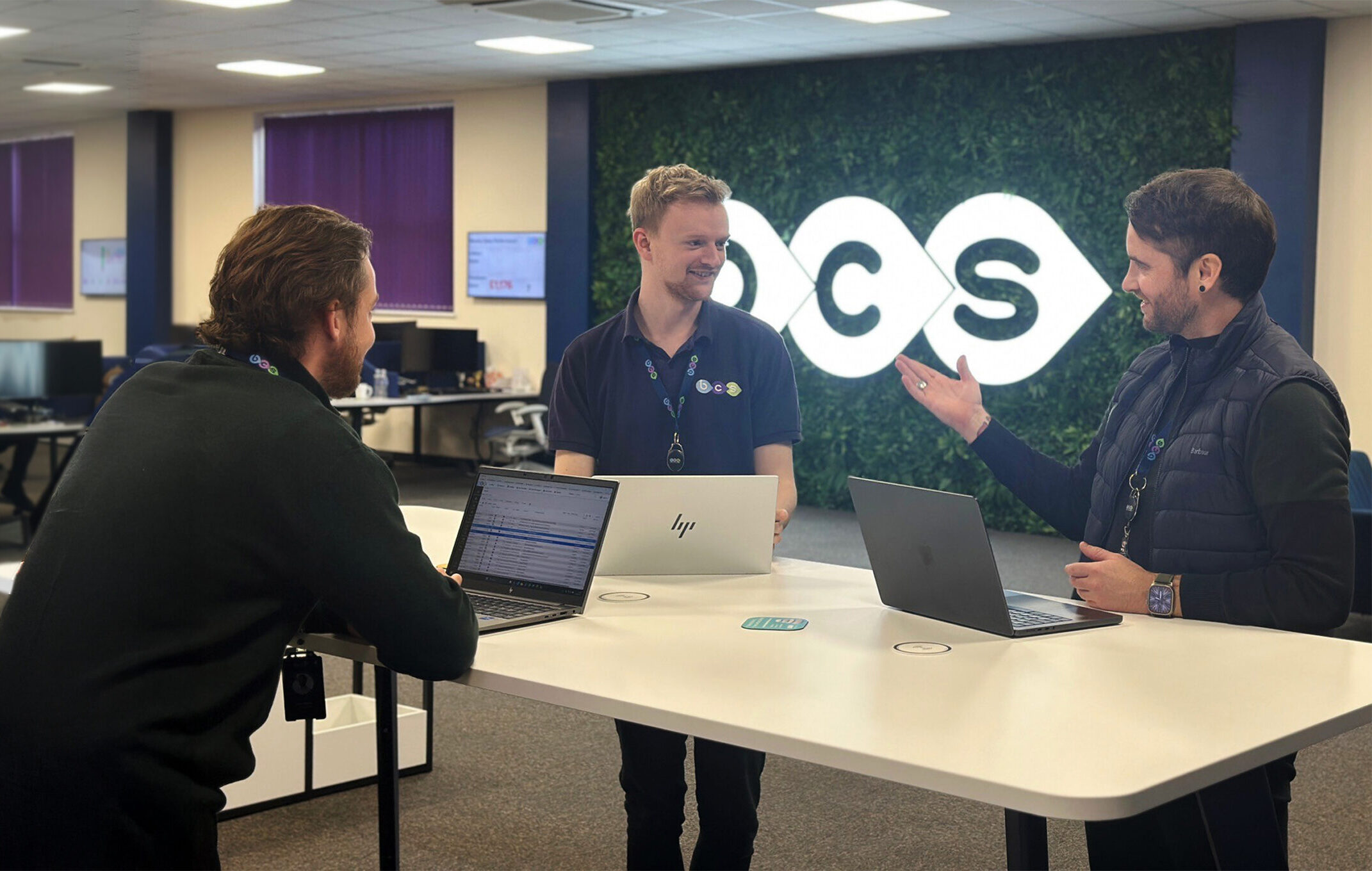 A managing director holding a meeting with two account managers discussing IT solutions for businesses.