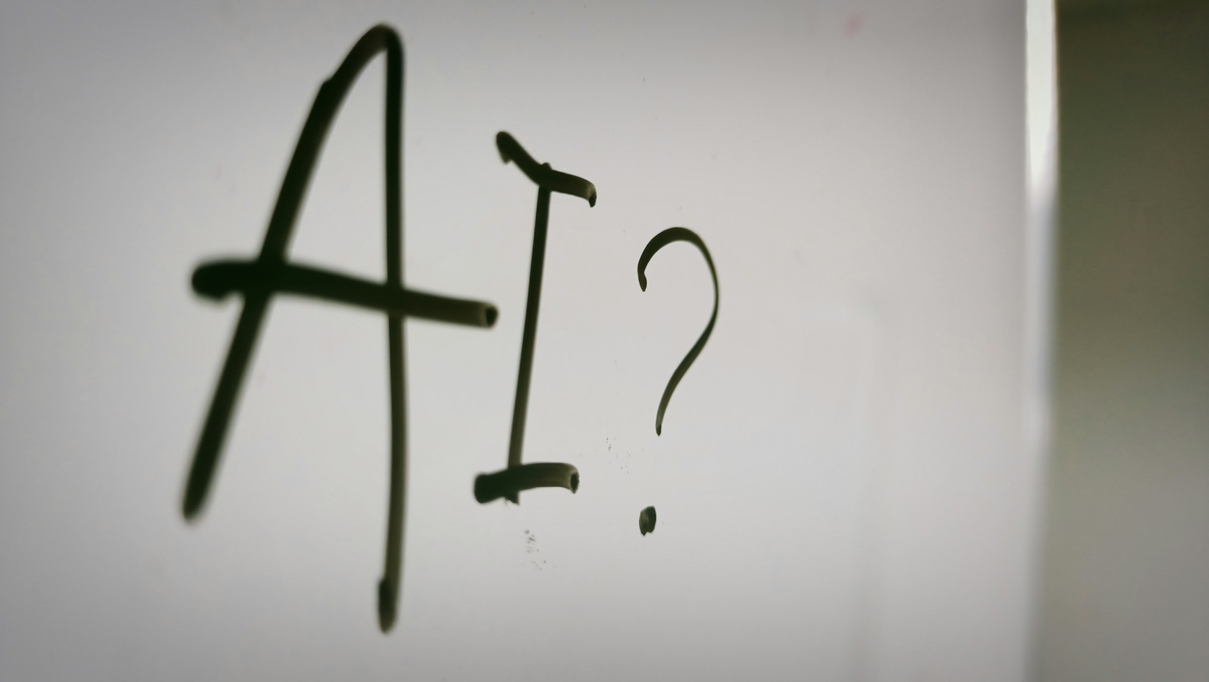 Whiteboard with "AI?" written on it.